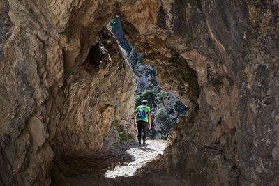 Rear view of person walking on rock