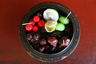 Directly above shot of dried kiwi and cherries in bowl on table