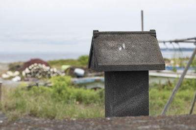 Close-up of metal structure on field against sky