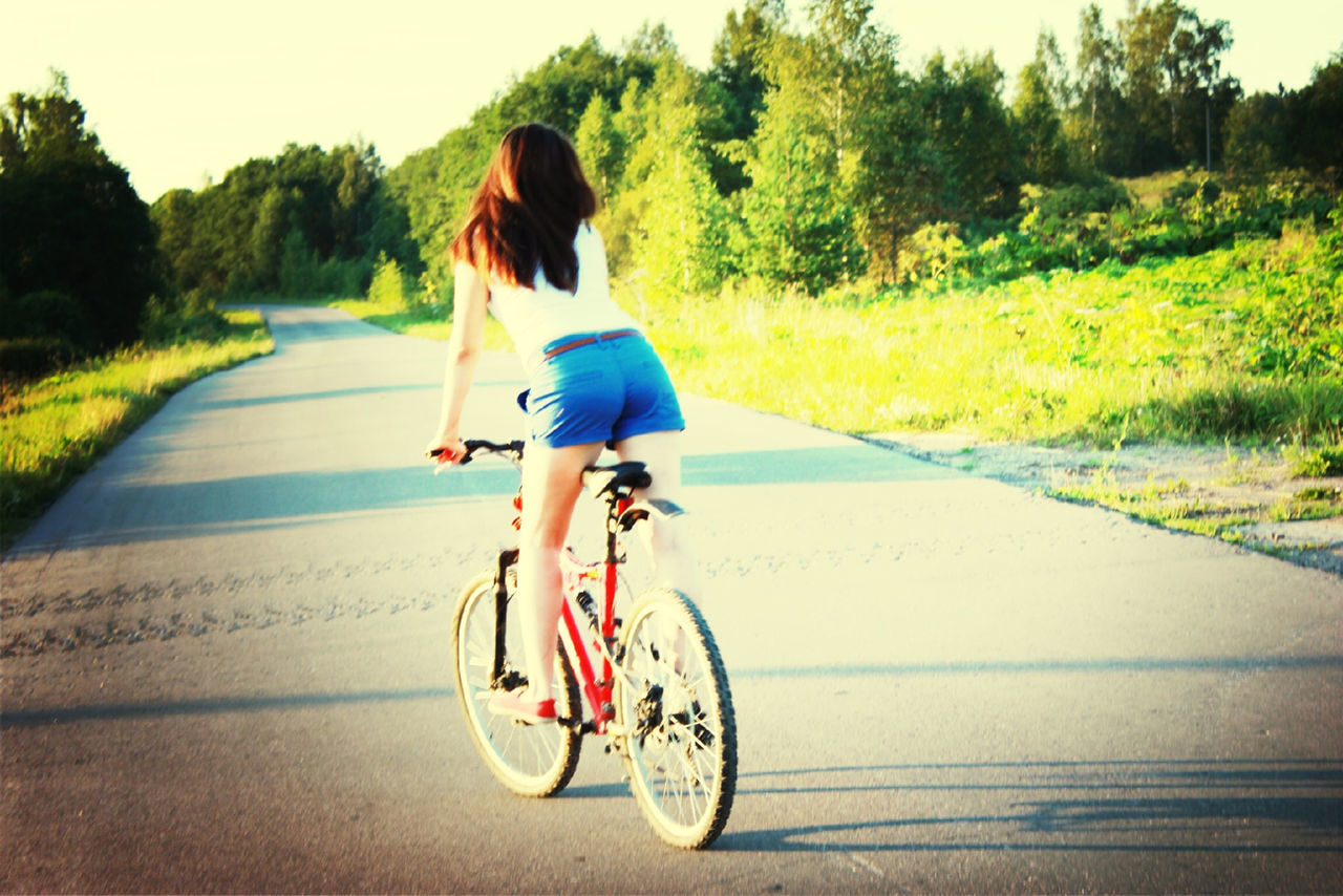 bicycle, transportation, mode of transport, land vehicle, riding, road, full length, cycling, lifestyles, tree, leisure activity, on the move, motion, side view, street, travel, sunlight, outdoors