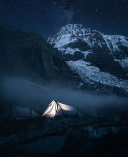Scenic view of snowcapped mountains against sky at night