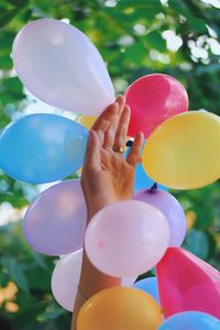 Close-up of hand holding balloons
