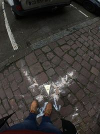 Low section of man standing on cobblestone