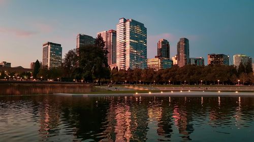 Swimming pool by lake against buildings in city