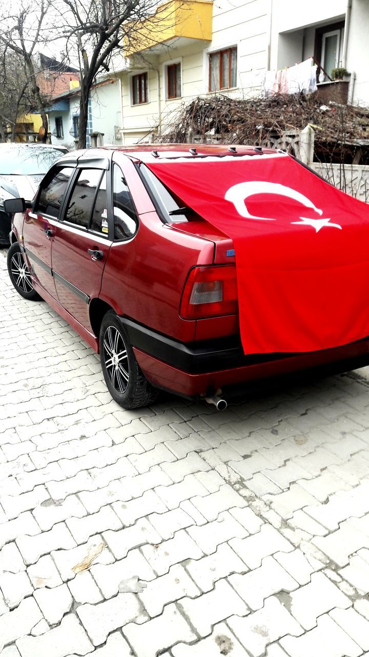 CAR ON STREET AGAINST BUILDINGS