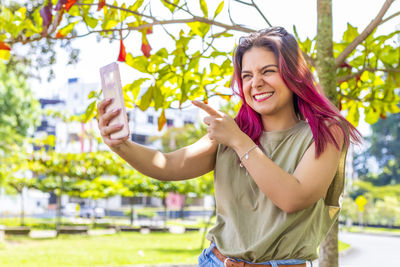 Portrait of a smiling young woman holding smart phone