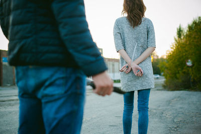 Rear view of man standing with knife against woman