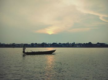 Boats in sea at sunset