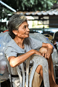 Senior woman looking away while sitting on chair