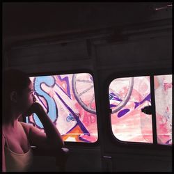 Close-up of young woman seen through window