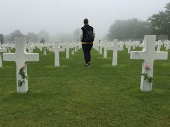 Rear view of woman walking at cemetery