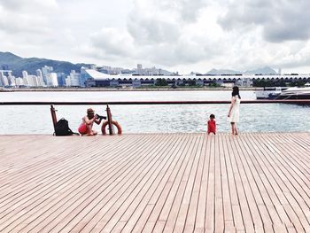Two people sitting on pier