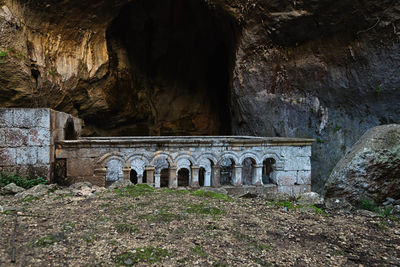 Abandoned built structure against rock formation