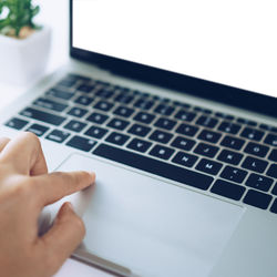 Close-up of hand using laptop