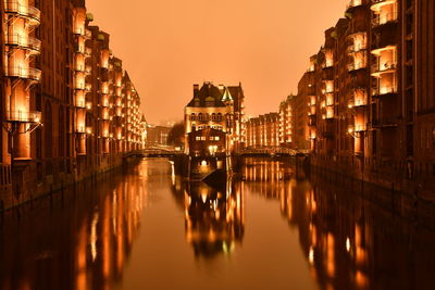 Reflection of buildings in water at sunset