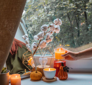 Girl decorates window sill in her room. home decoration for holidays, thanksgiving, halloween