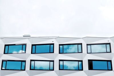 Low angle view of glass building against sky