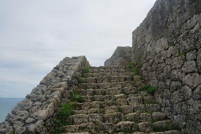 View of stone wall against cloudy sky