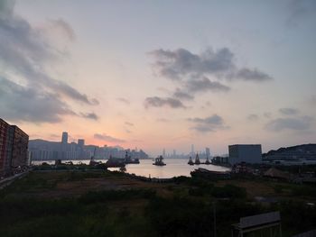 Scenic view of sea and buildings against sky during sunset