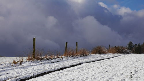 Snow covered field against sky