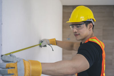 Midsection of man working with yellow umbrella