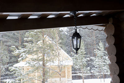 Low angle view of electric lamp hanging on roof of building