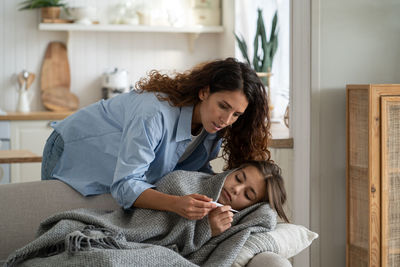 Side view of mother and daughter at home