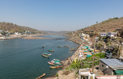 High angle view of townscape by sea against clear sky