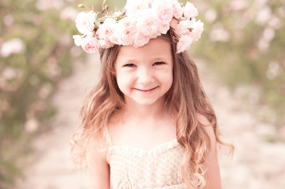 Portrait of cute girl wearing wreath at farm