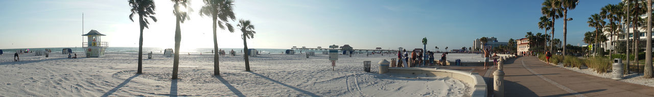 Panoramic view of people on beach against sky