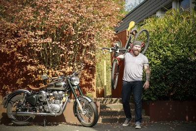 Portrait of man switching from motorbike to bicycle