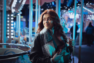 Portrait of young woman standing in city