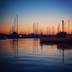 Sailboats in sea at sunset