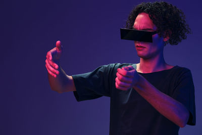 Man wearing futuristic glass against purple background
