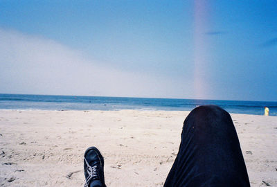 Low section of person standing on beach