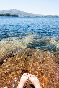 Midsection of person in sea against sky