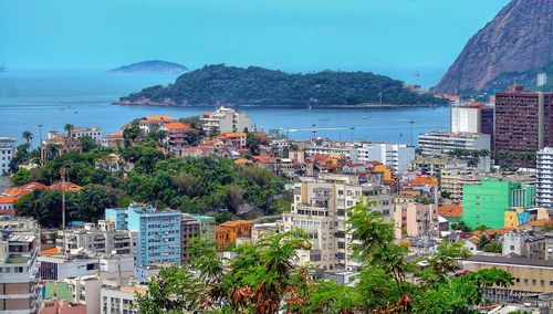 High angle view of city by sea against sky