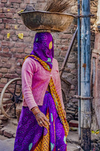 Woman standing against brick wall