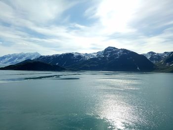Scenic view of lake by mountains against sky
