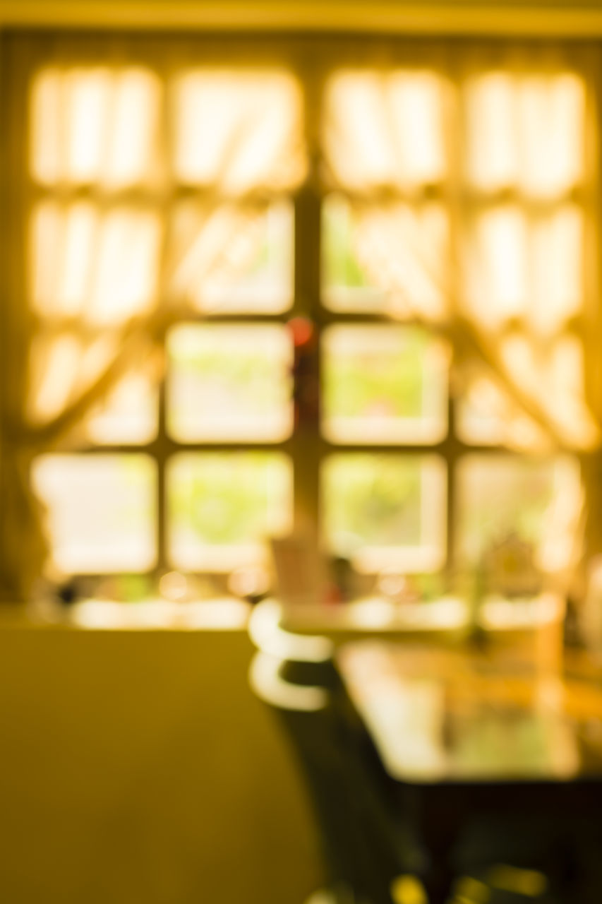 CLOSE-UP OF GLASS ON TABLE AGAINST WINDOW