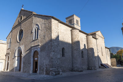 Low angle view of old building against clear blue sky