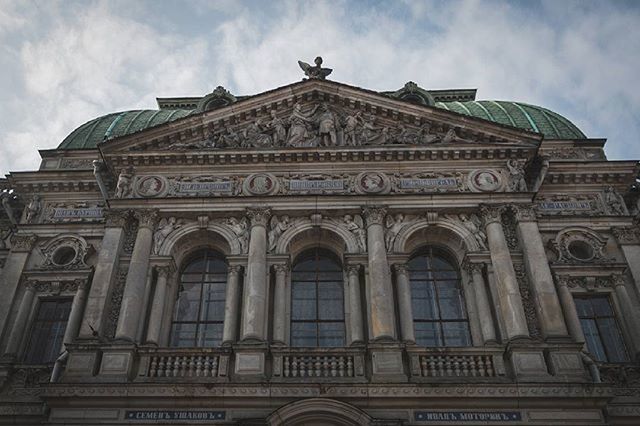 architecture, built structure, building exterior, low angle view, sky, facade, arch, cloud - sky, art and craft, history, human representation, travel destinations, art, famous place, city, window, text, sculpture, outdoors, statue