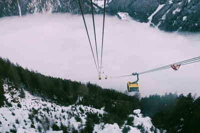 Overhead cable car over snowcapped mountains during winter