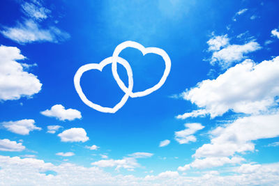 Low angle view of heart shape against blue sky