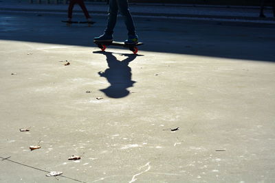 Low section of person skateboarding on road