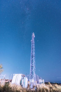 Low angle view of communications tower against blue sky