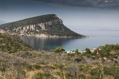 Scenic view of sea and mountains against sky