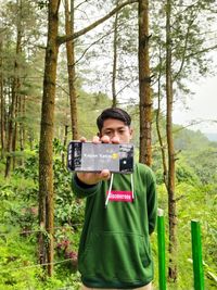 Portrait of a smiling young man in forest