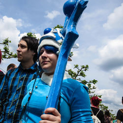 Low angle view of man standing against blue sky