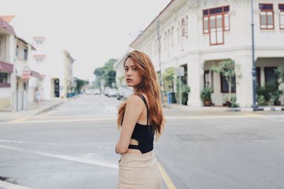 Young woman standing on road in city